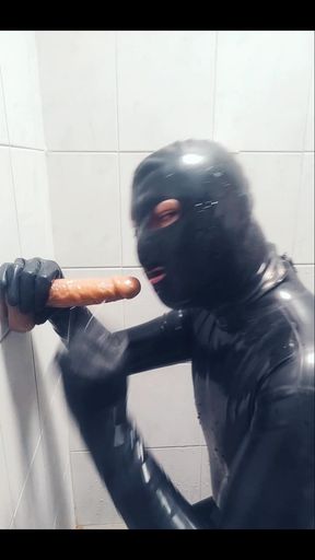 Rubber boy playing with a dildo in chastity p1