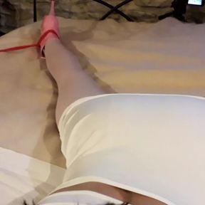 Laura is wearing a sexy white dress, pink pantyhose and platform heels, tied up and gagged in a bed