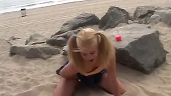 A petite blonde teen teases and fingers her tight pussy on the beach