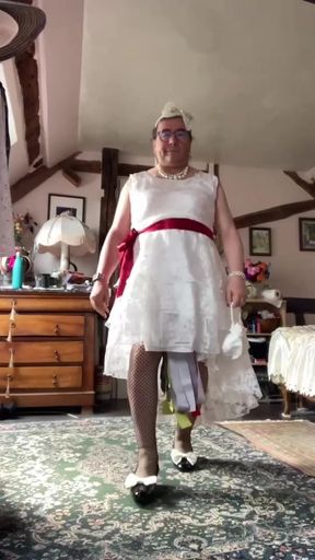 In an outfit with a long white lace dress styled like a wedding dress for an evening.