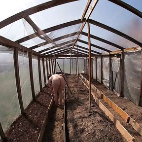 Nude house wife working in the greenhouse