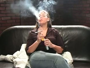 Hot brunette girlfriend fully dressed smokes a cigarette