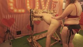 BDSM Mistress Pegging her slave in the stocks with a huge strapon