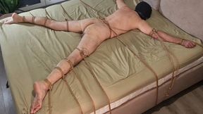 Male slave is spreadeagled on the bed and spanked