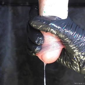 Milking table closeup: The mistress massages the sperm out of the cock with latex gloves.