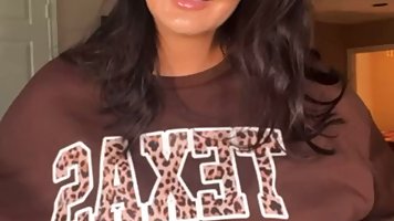 Stunning brunette is sucking a big, fake dick and rubbing it with her massive boobs