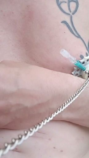 6 needles through the nipples stretched by plastic flower ring with holes on the terrace outside   Clip 1