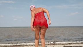A Lonely Housewife by the Sea in a Red Net Takes off Her Panties and Bra and Shows Her Charms in Front of the Camera