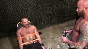 Soldier Dirk Caber takes all the painful shock from his big balls and naked nipples