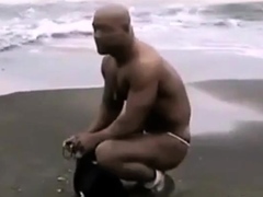 Asian bodybuilder barely covered at the beach