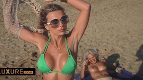 Two bombshell MILF with big round boobs please each other's pussies with their tongues on a sandy beach