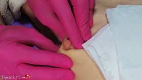 Man beautician plucks hair on nipples of girl on depilation and massaging tits in red latex gloves