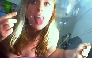 Blondie jerks off and eats her own cum from a glass sheet