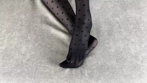 Girl in black nylon tights caresses her legs in different poses