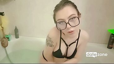 Young European brunette in glasses and black bra gets naked in the bathtub.