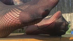 Wiggling toes in fishnet hose