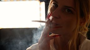 Blonde Eve with long red nails, exhaling smoke in slow motion