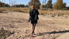 A girl in high-heeled shoes walks through sticky mud and gets her shoes dirty