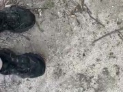 Dirty sneakers stepping on pine cones in the park