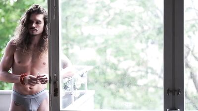 Handsome guy with long hair and muscles shows his body off