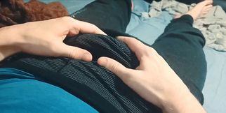 A guy in sweatpants is basking and caressing himself