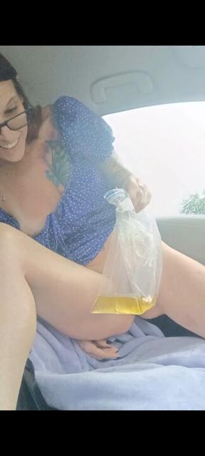 Peeing in a plastic bag in my car to avoid the rain.