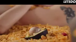 Tattooed redhead plays with her wet pussy in a bed of cereal