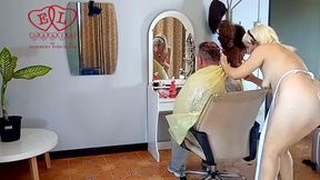Nudist barbershop. Nude lady hairdresser in an apron. camera 1