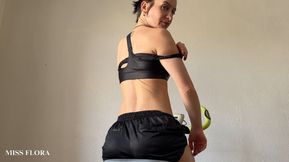 Fit girl rides exercise bike and shows off her perfect ass in gym shorts