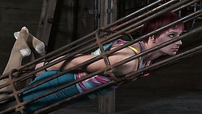 Frisky red-haired hussy gets her body locked in huge metal cage