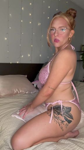 Bikini-clad redhead jiggles her glasses while riding a pillow at home