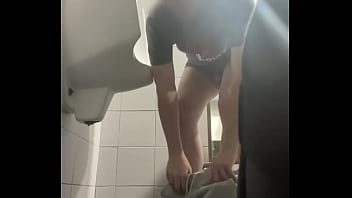 2 boys in sneakers having fun at public toilets&#039_ urinal