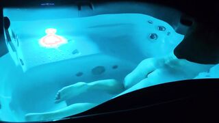 A fellow takes a bathtub at night in a lit tub and gets sexually aroused