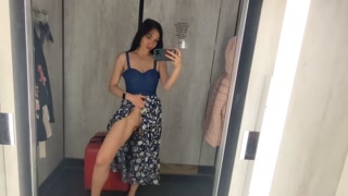 Busty  hot brunette is trying dresses in the store
