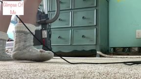 Woman in long sock vacuums with slipper socks