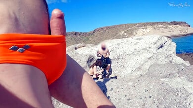 Exposed on the rocks: a public handjob leads to a cumshot under the sun