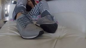 Home from the gym, relaxing on the sofa in sweaty sneakers and no socks SWEATY FEET