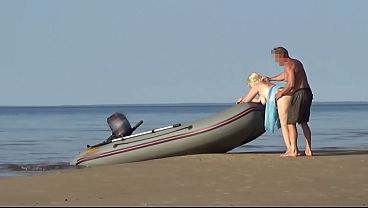 Blonde MILF gives a blowjob and shows off her round ass at the beach