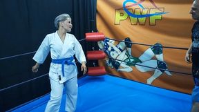 Asian girl in a gi wrestles a guy