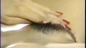 Thai babe plays with her wet, hairy pussy