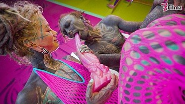 Tattooed dominatrix in pink Fishnet