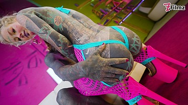 Tattooed dominatrix in pink Fishnet