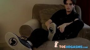 Skinny twink massages his feet and strokes massive dick