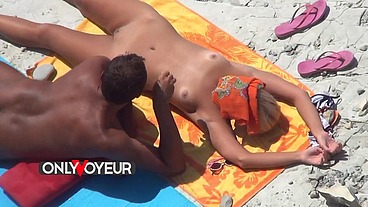 Beach Voyeur. Naked teen blonde soaks up the sun with her wealthy old man.