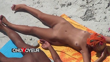 Beach Voyeur. Naked teen blonde soaks up the sun with her wealthy old man.