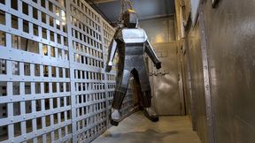 Encased in Steel - Heavy and Elise Graves - Heavy is locked inside a heavy steel person-shaped tomb before being taunted and suspended by Elise