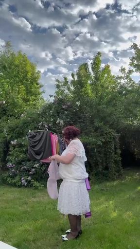 Dressed in a white lace dress to hang the laundry