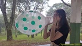 Katie Blows to Pop a Clear Polka Dot Balloon