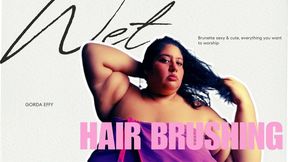 A scantily clad brunette brushing her hair