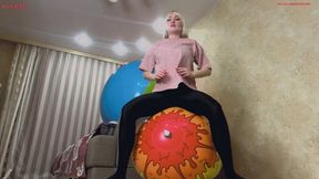 Alla does fitness with two large beach balls and happily jumps on them